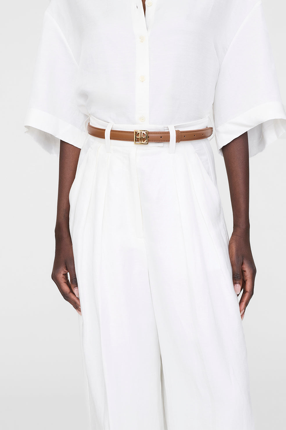 Anine Bing Monogram Belt i cognac – klassisk læderbælte med guld logospænde og justerbar lukning.