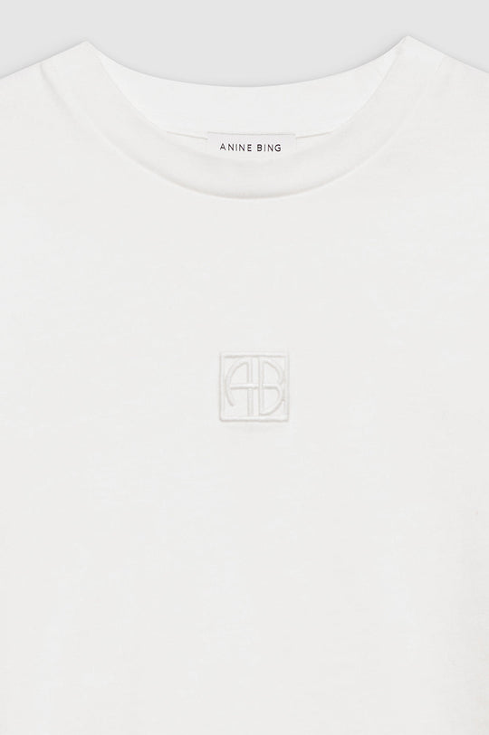 Anine Bing Myers Cropped Tee – cropped oversized T-shirt i 100% bomuld med broderet monogram. Minimalistisk design i ivory, perfekt til casual chic looks.