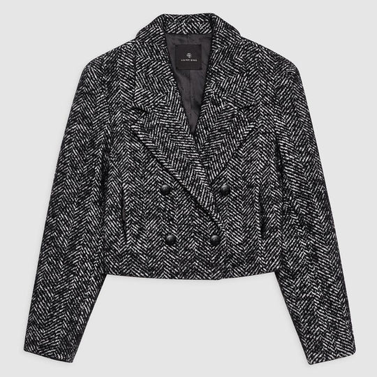 Anine Bing Vienna Blazer i sort og hvid tweed med herringbone-mønster. Cropped snit, dobbeltradet lukning og sofistikerede detaljer for et elegant look.