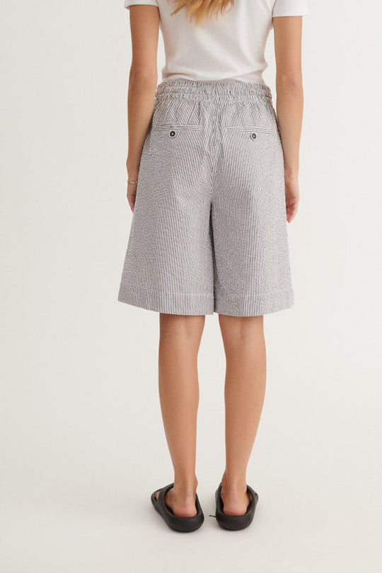 Basic Apparel Asta Shorts i økologisk bomuld med blå-hvide striber, elastik i taljen, bindebånd og knælængde. Regular fit og bæredygtigt design.