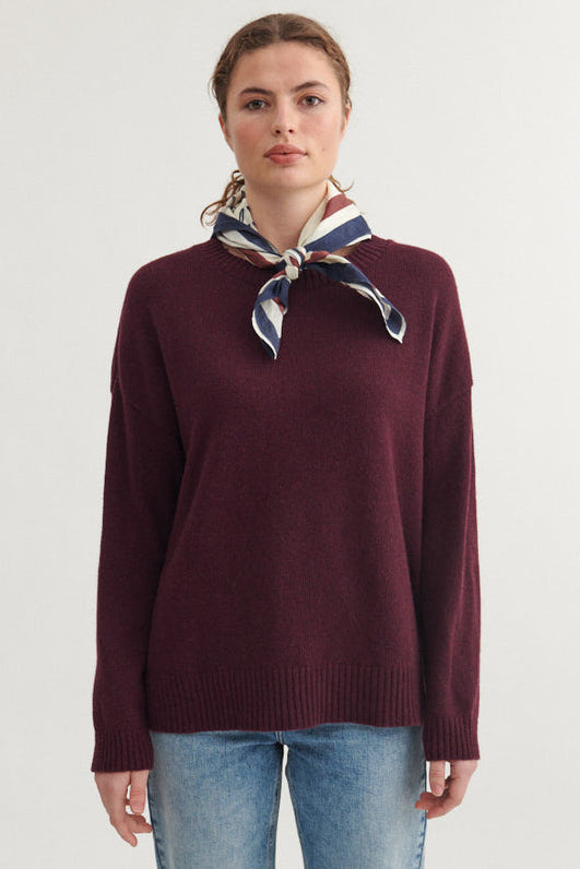 Basic Apparel Lise O-Neck Sweater i farven Bordeaux Truffle, strikket i en bæredygtig blanding af genanvendt lammeuld og polyamid, med rund hals og afslappet pasform.
