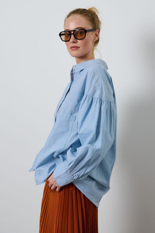 La Rouge Minna Shirt – lyseblå bomuldsskjorte med feminine rynkedetaljer og ovale ærmer.