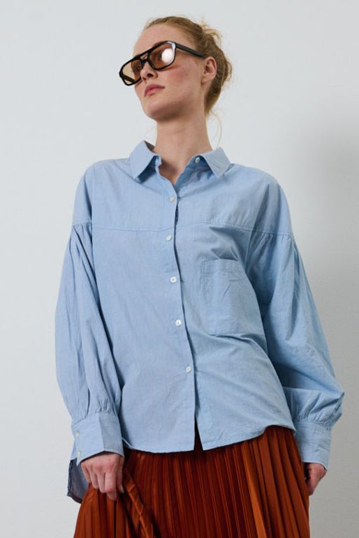 La Rouge Minna Shirt – lyseblå bomuldsskjorte med feminine rynkedetaljer og ovale ærmer.