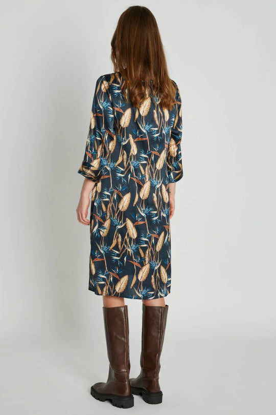PBO Silky Cameron Dress i blå med botanisk print – elegant silkekjole med bådudskæring, A-formet pasform og 3/4-ærmer.
