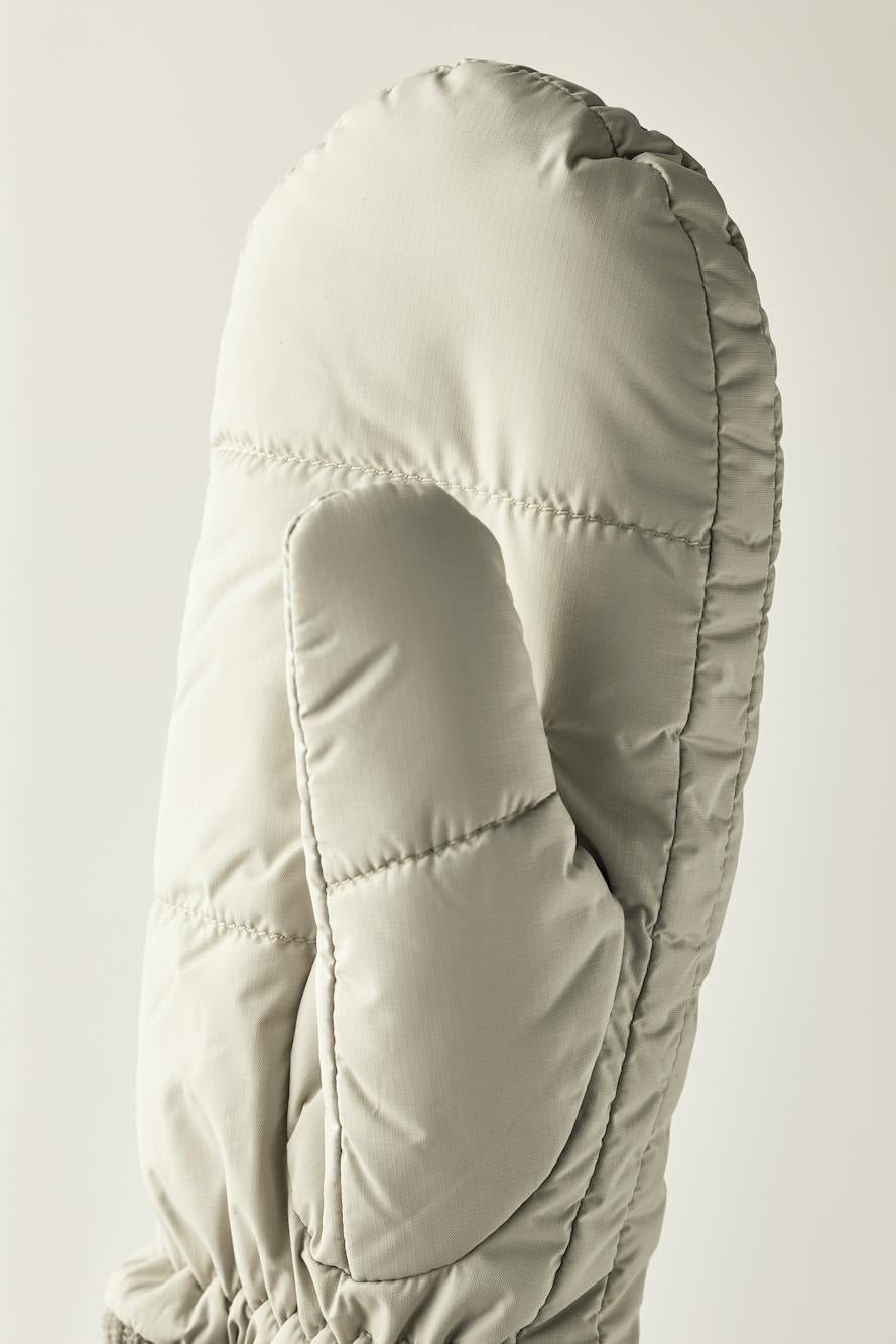 Hestra Otra Luffer i natural beige – quiltede, vindtætte og vandafvisende luffer med PrimaLoft Gold isolering og blødt børstet polyesterfor.
