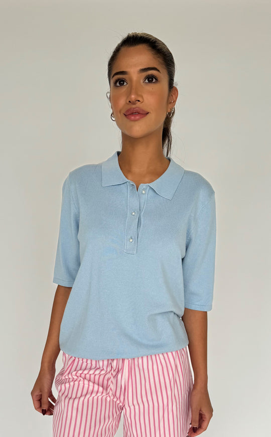 Diane Polo SS fra Continue i light blue – feminin polo med klassisk krave, perleknapper og let strikket kvalitet.