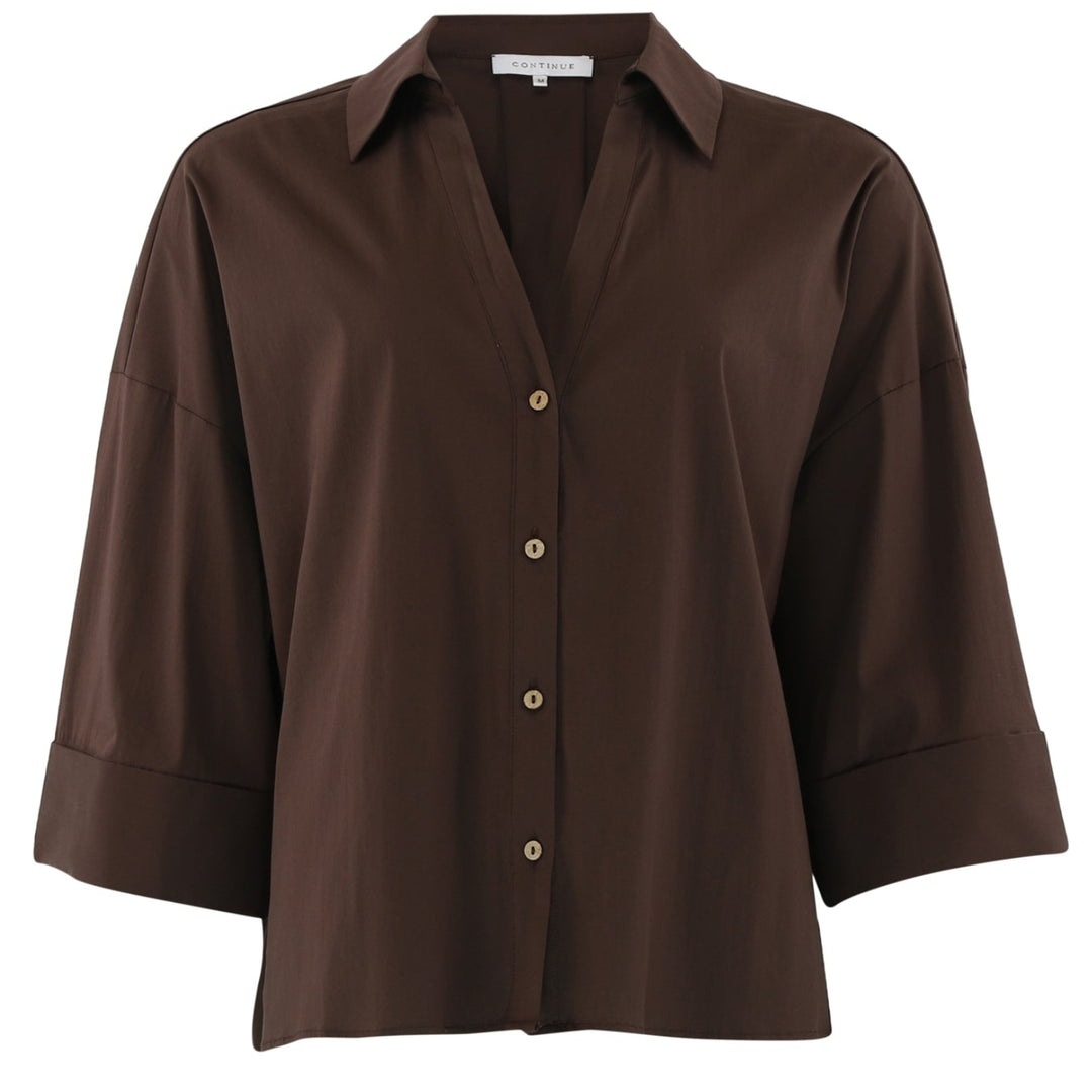 Continue Augusta Shirt i brown – oversize skjorte med skjortekrave, lange ærmer og moderne, afslappet pasform.
