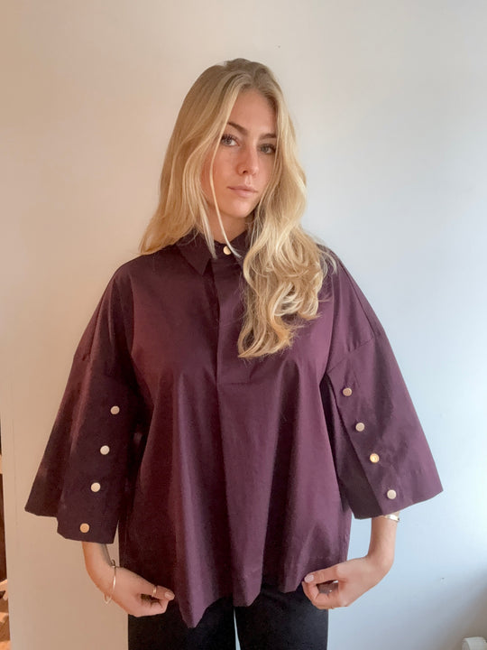 Continue Klara Skjorte i bordeaux – feminin oversized skjorte med stolpelukning og naturknapper på ærmerne. Eksklusive detaljer.
