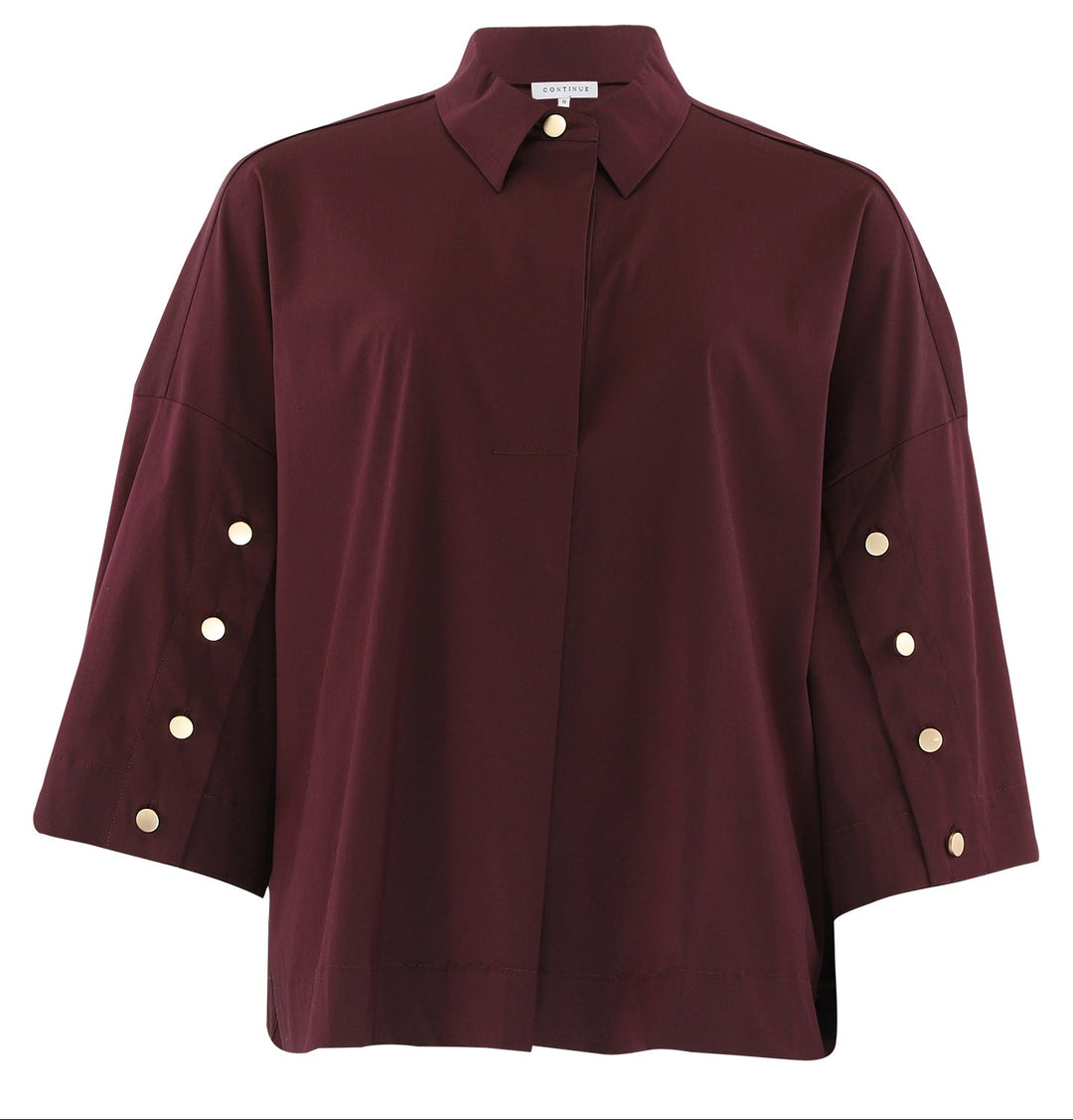 Continue Klara Skjorte i bordeaux – feminin oversized skjorte med stolpelukning og naturknapper på ærmerne. Eksklusive detaljer.