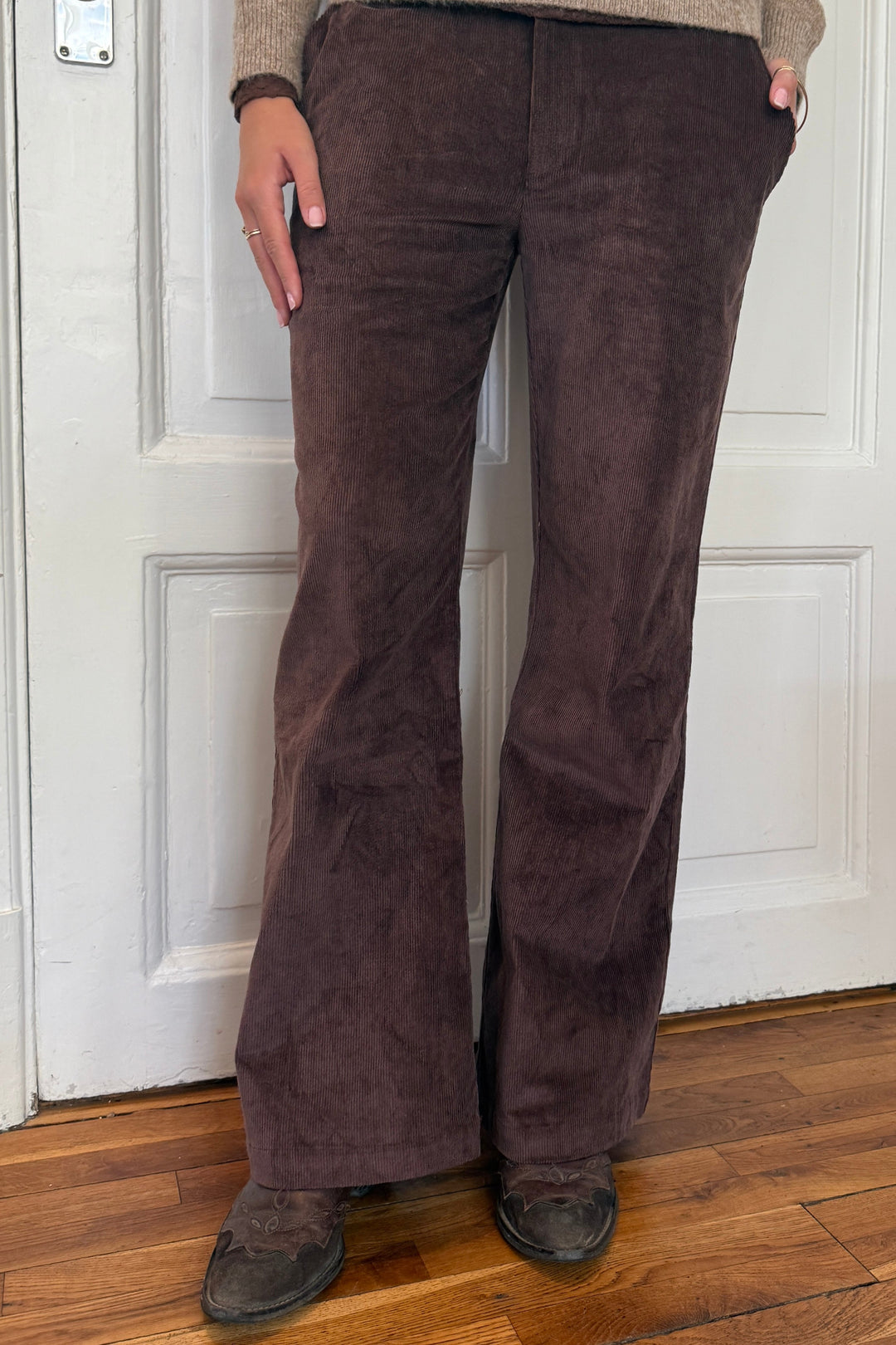 Continue Roberta Corcorey bukser i brun fløjl – bukser med vide ben, elastik i taljen, skrålommer samt lynlås- og knaplukning.
