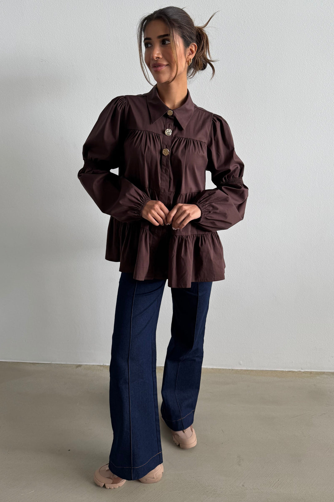 Continue Sanna Gold Buttons skjorte i dark brown – mørkebrun skjorte med guldknapper, flæser, pufærmer og løs pasform.
