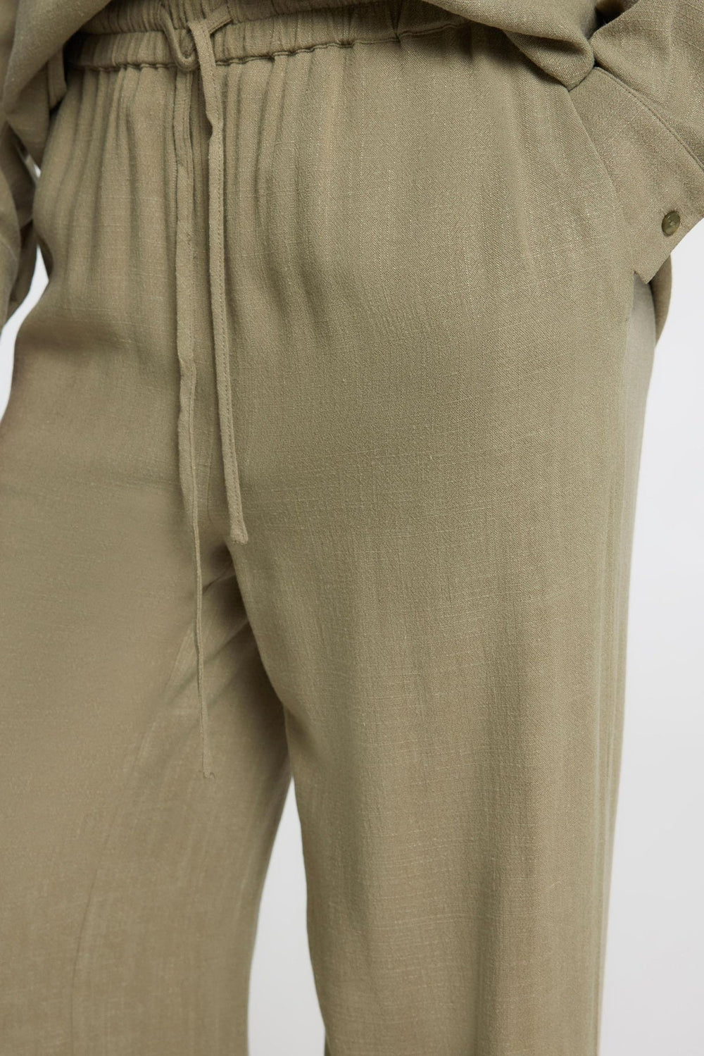 Selected Femme Viva-Gulia HW Long Sun Pant i hørblanding med høj elastisk talje, justerbar snor, skårede sidelommer og loose fit. Perfekte forår- og sommerbukser.