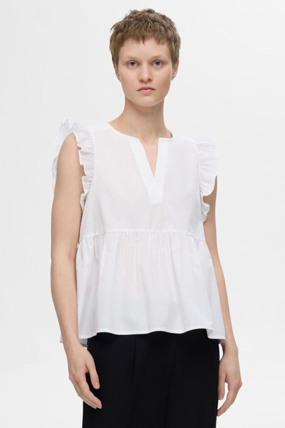 Selected Femme Blair-Ida top i hvid økologisk bomuld med flæsekanter, V-hals og regular fit. Feminin, åndbar og del af et matchende sæt. 