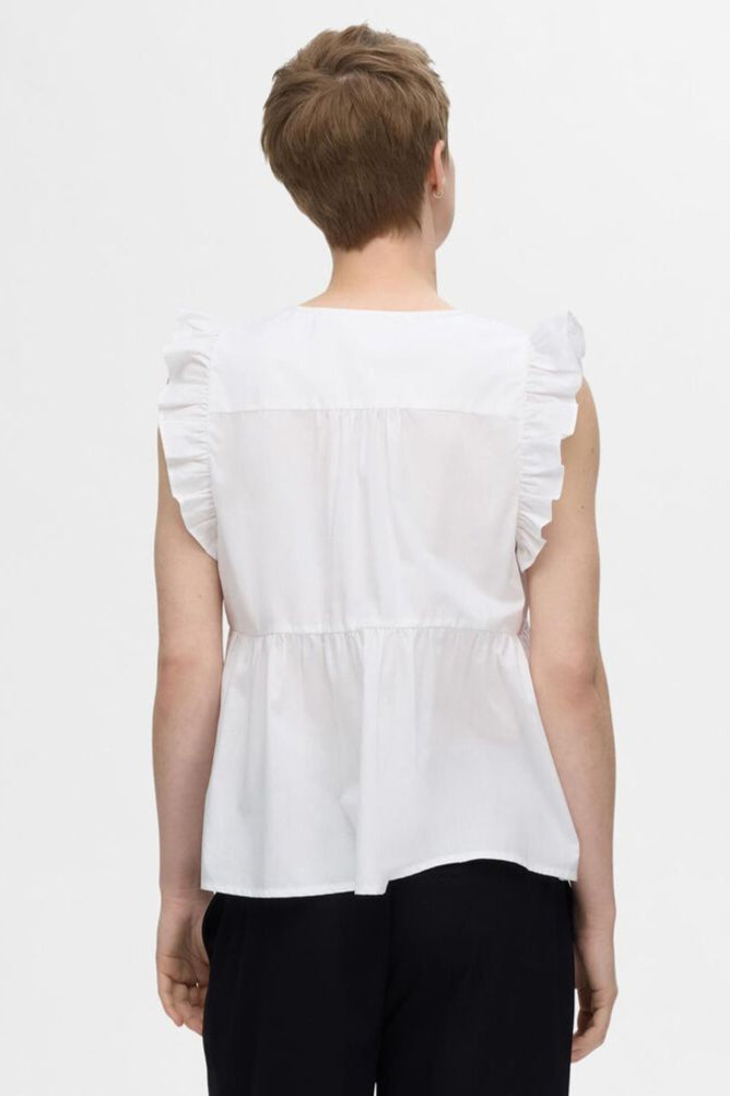 Selected Femme Blair-Ida top i hvid økologisk bomuld med flæsekanter, V-hals og regular fit. Feminin, åndbar og del af et matchende sæt. 