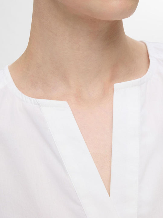 Selected Femme Blair-Ida top i hvid økologisk bomuld med flæsekanter, V-hals og regular fit. Feminin, åndbar og del af et matchende sæt. 