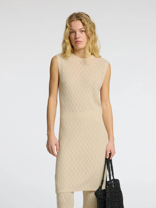 Selected Femme Agny SL Knit Dress i birch – strikkjole i hæklet stil med rund hals, ribkanter og slids i siden. Regular fit og uforet.
