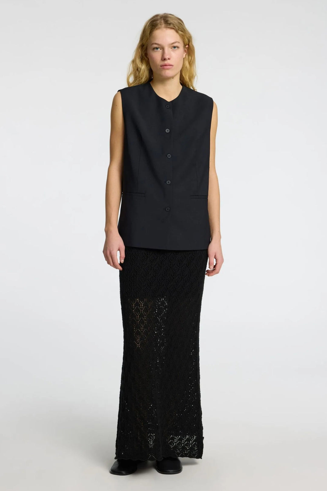 Selected Femme Niva HW Knit Skirt i black med højtaljet elastisk linning, delvist foret og hæklet mønster – strikket maxinederdel med cool vintage-look.
