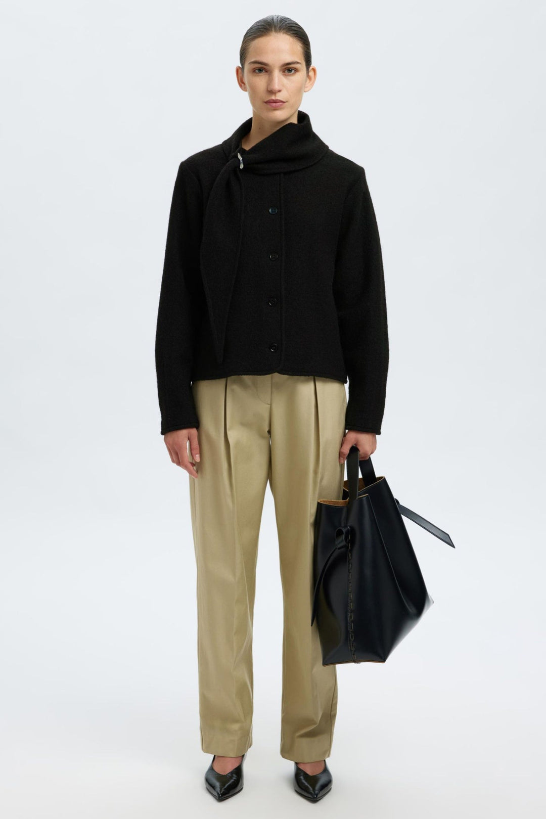 Selected Femme Darla LS Knit Jacket i sort med krave, metalspænde, knaplukning og lange ærmer i 100% uld.
