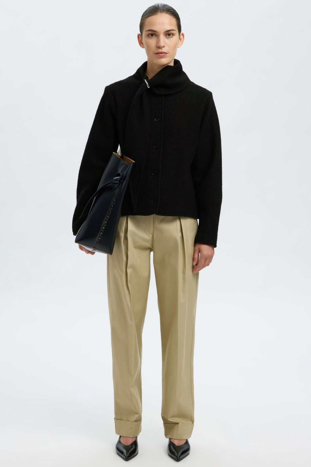 Selected Femme Darla LS Knit Jacket i sort med krave, metalspænde, knaplukning og lange ærmer i 100% uld.
