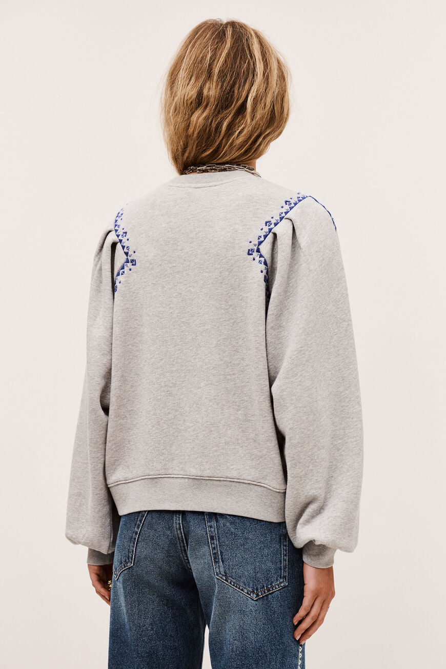 ba&sh Mesta sweatshirt i grå med loose fit, puffede ærmer og broderede folk-inspirerede detaljer.