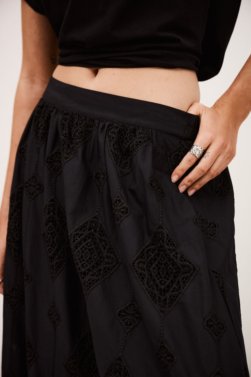ba&sh Mona maxi nederdel i sort med broderie anglaise, flared silhuet og elastisk talje.