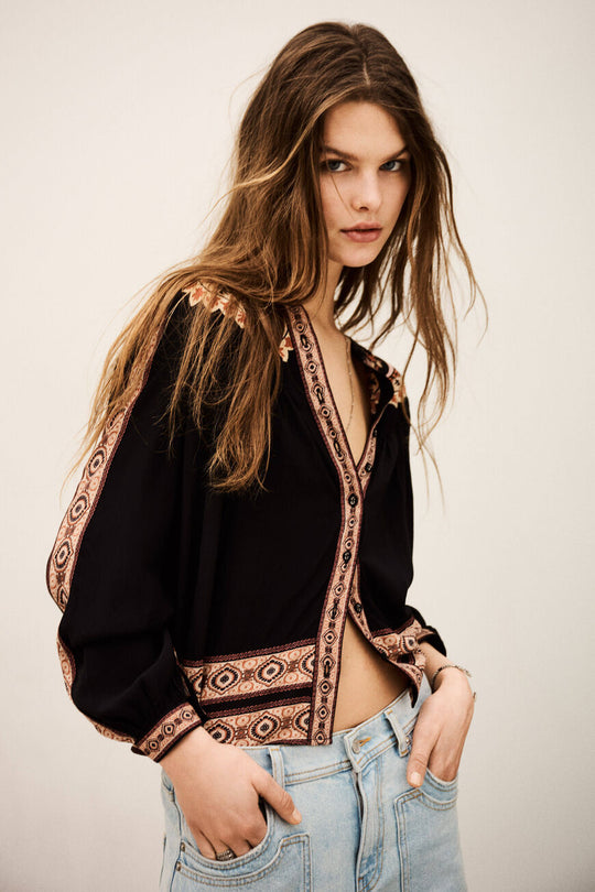 ba&sh Valda Shirt i carbone – løstsiddende mønstret skjorte med roset-applikationer, klassisk krave og let puffede lange ærmer.
