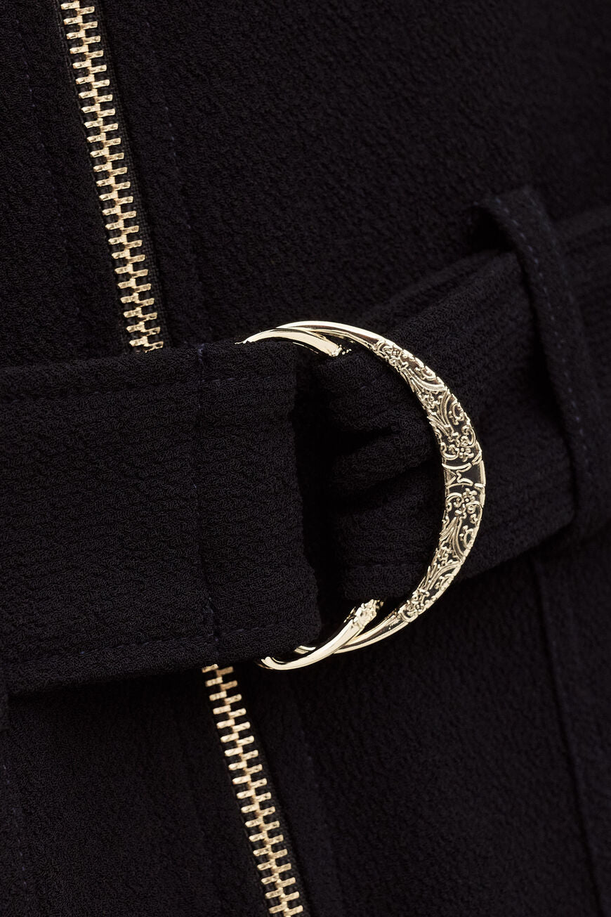 ba&sh Combinaison Fleur Jumpsuit i marine – buksedragt med lige pasform, bælte i taljen, lange ærmer, brystlommer og lynlåslukning foran.
