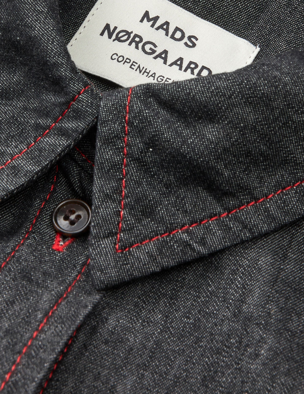 Mads Nørgaard Air Denim Crissy skjortekjole i sort med rød kontrastsyning. Let denim i 65 % økologisk bomuld. Knælang med klassiske detaljer. 