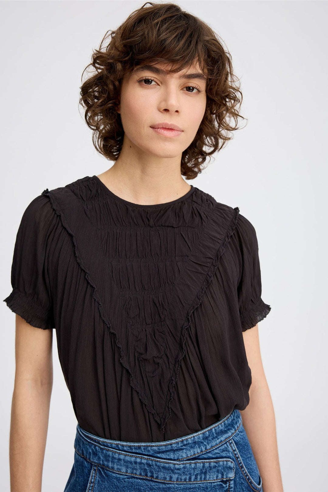 Perilla Top fra Munthe – elegant sort skjorte i bæredygtig viscose med smukke flæsedetaljer.