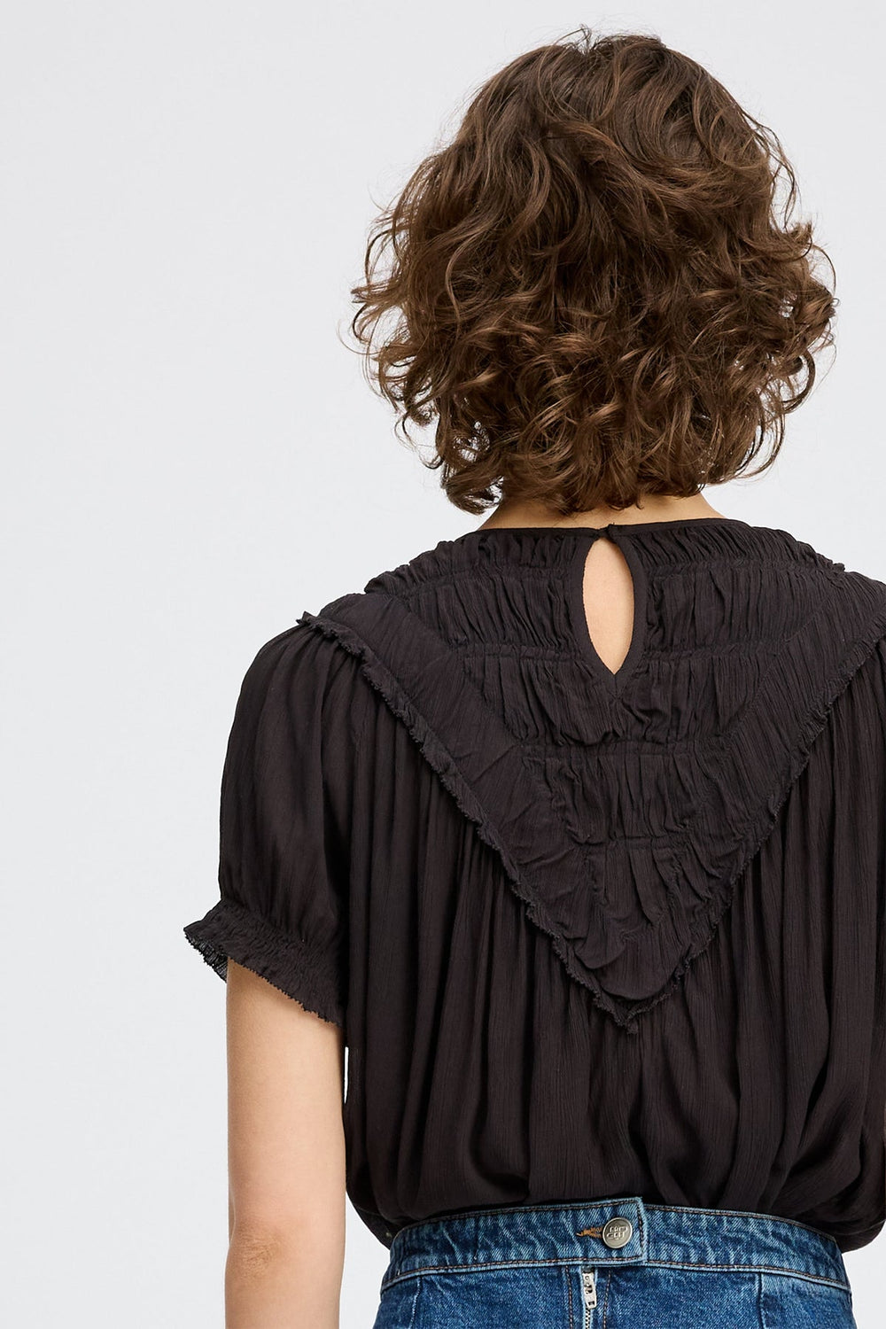 Perilla Top fra Munthe – elegant sort skjorte i bæredygtig viscose med smukke flæsedetaljer.