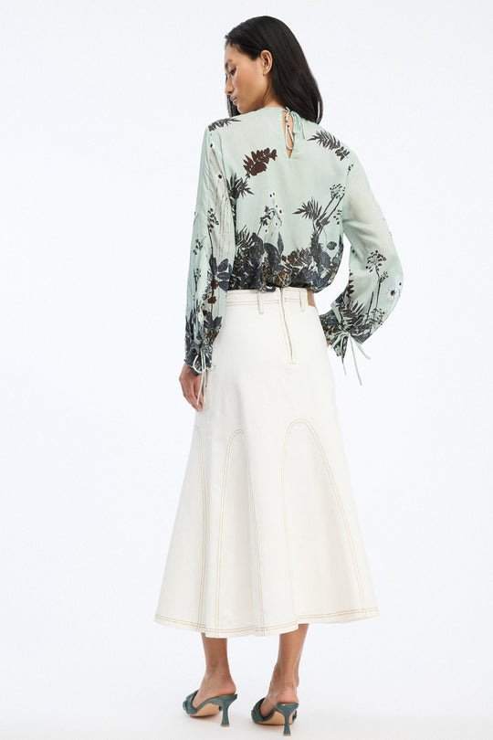 Munthe Basilia Top – Mint. Top med flerfarvet botanisk print, rund hals med bindedetalje og lange ærmer med bånd ved håndleddene.
