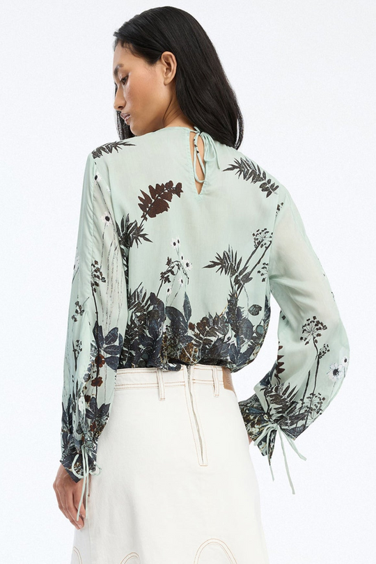 Munthe Basilia Top – Mint. Top med flerfarvet botanisk print, rund hals med bindedetalje og lange ærmer med bånd ved håndleddene.
