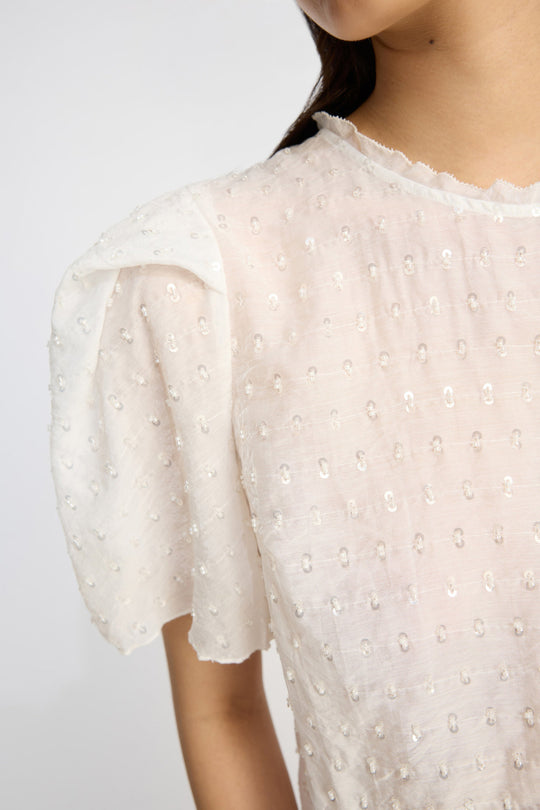 Munthe Brown Top – Ivory. Top med pailletdetaljer, let puffede korte ærmer, rund hals og peplum-detalje i bunden.
