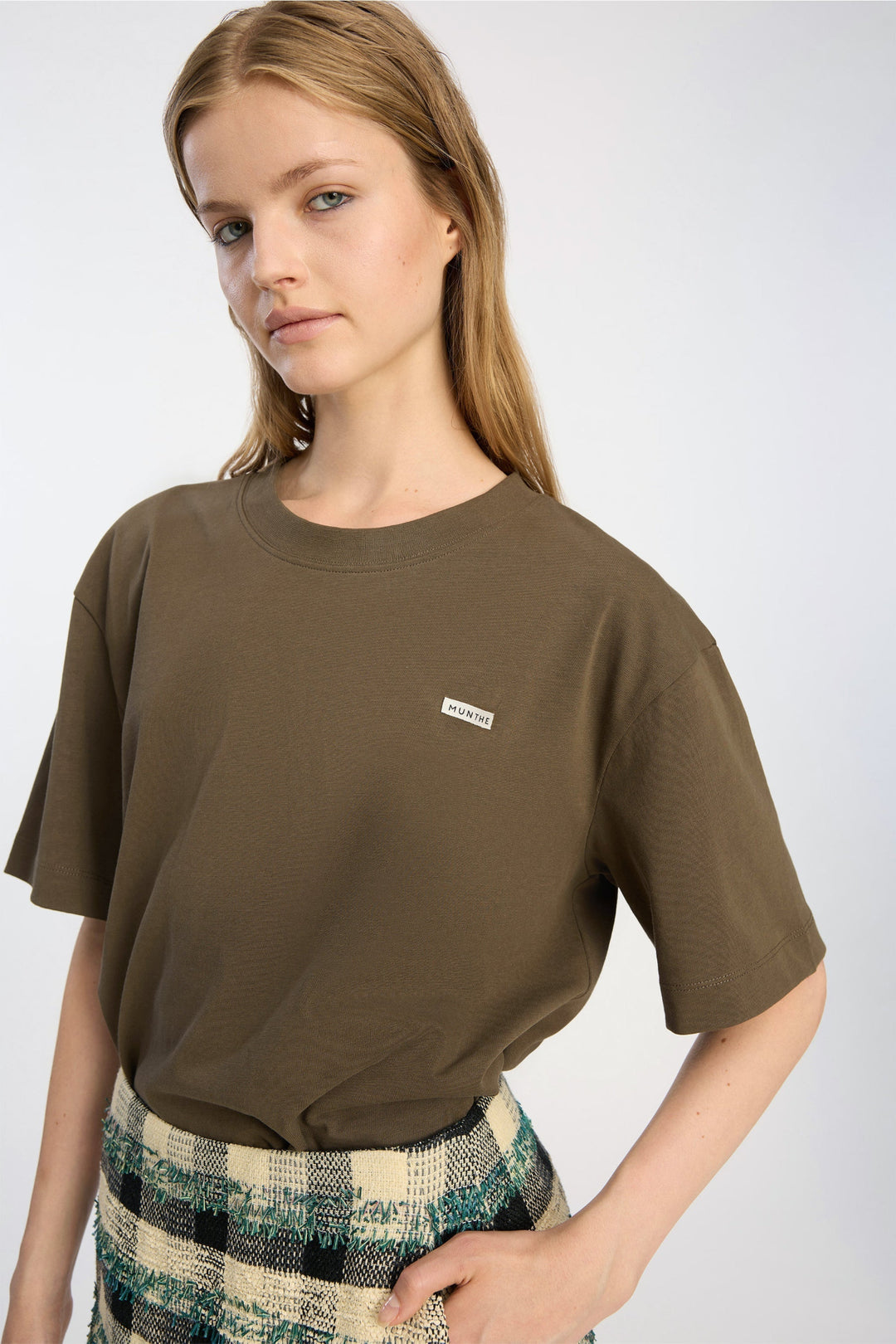 Munthe Bellamy Jersey – Brown. Cropped t-shirt med rund hals, korte ærmer og diskret MUNTHE-logo i blød jersey.

