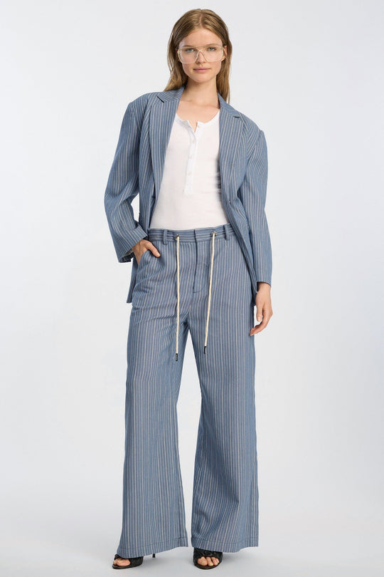 Munthe Bobey Pants – Blue. Bukser med bred benprofil, justerbart bindebånd i taljen, front- og baglommer og løs pasform.

