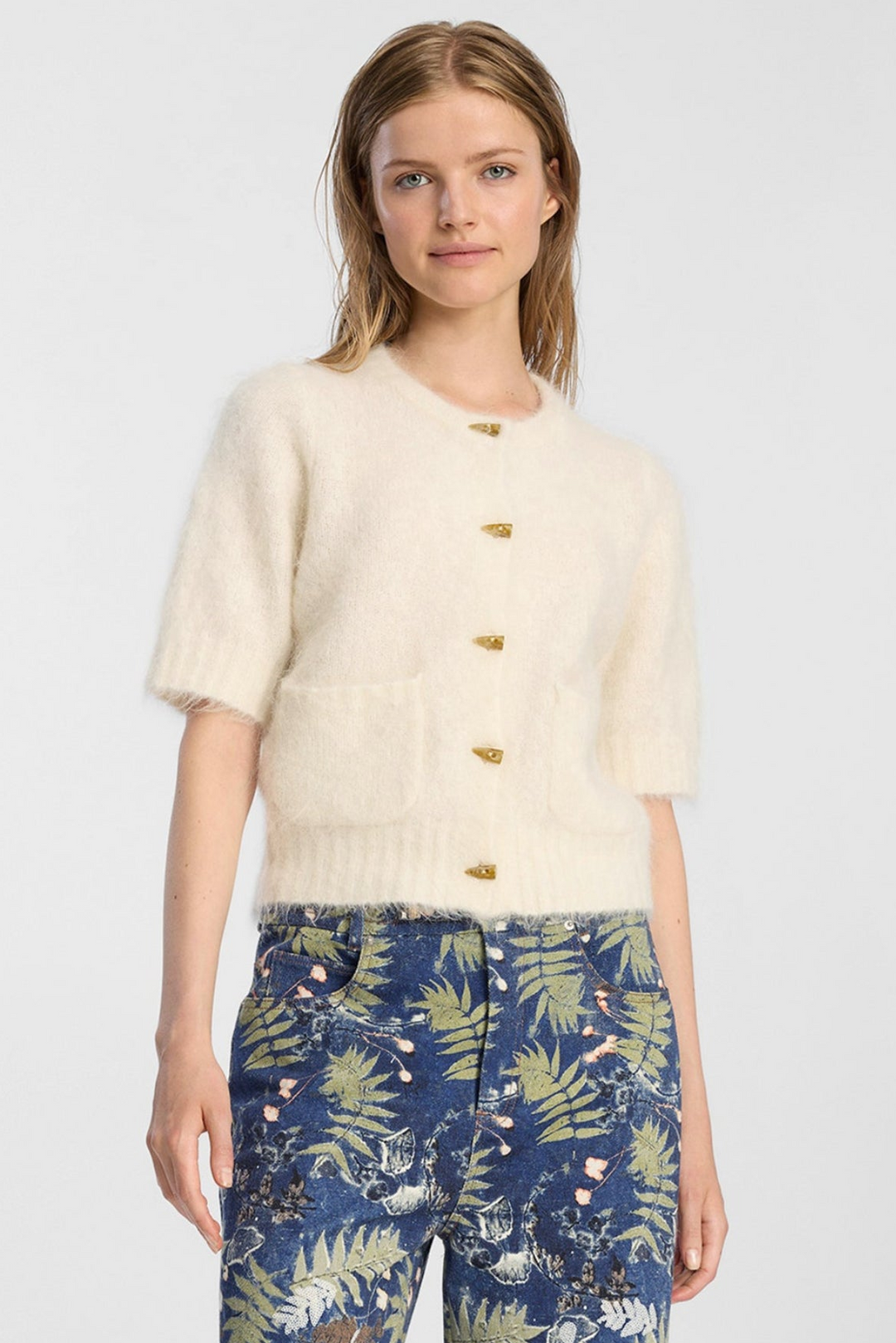 Munthe Locca Knit i ivory – kort strikcardigan med korte ærmer, knaplukning og forlommer med børstet finish.
