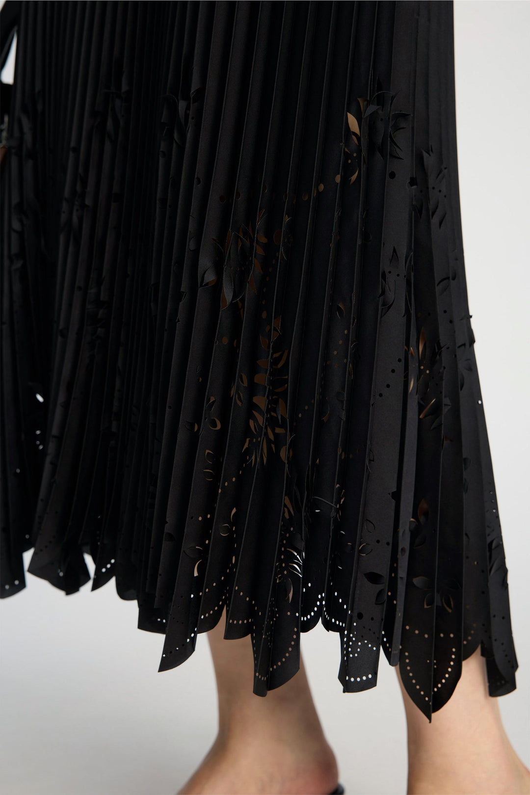 Munthe Charming Skirt – Black. Plisseret midi-nederdel med laserskårne detaljer og elastisk talje med diskret logo.