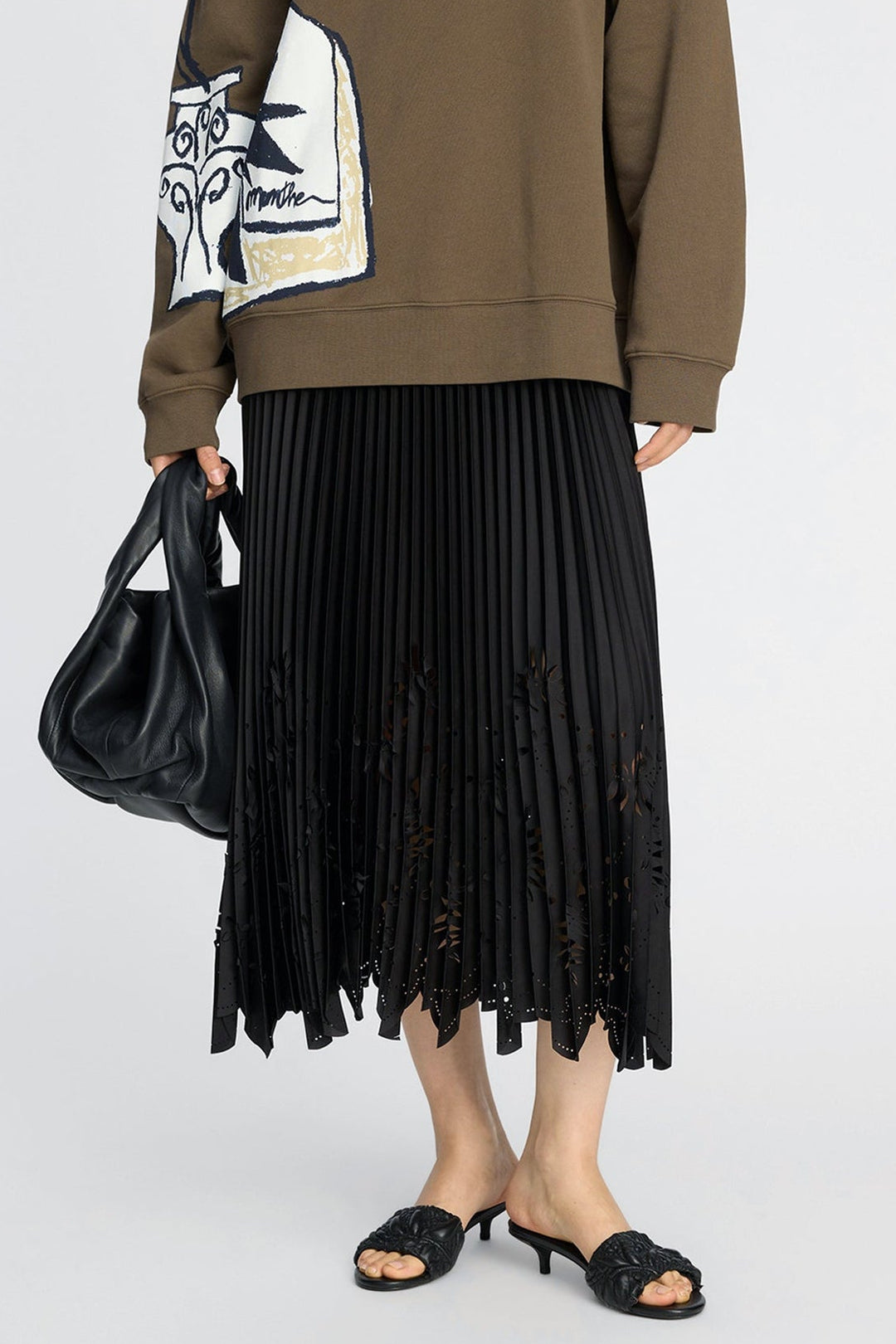 Munthe Charming Skirt – Black. Plisseret midi-nederdel med laserskårne detaljer og elastisk talje med diskret logo.