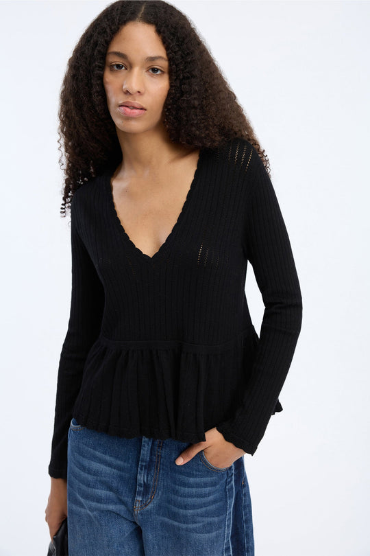 MUNTHE Visiona Knit i black med V-udskæring og peplumkant.