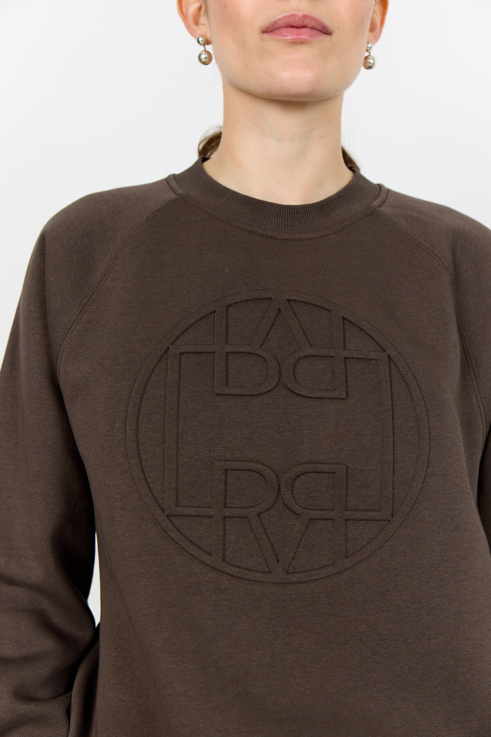 Levete Room LR-Nuka 11 sweatshirt, lavet af økologisk bomuld og genanvendt polyester, med cirkulært logo på forsiden.