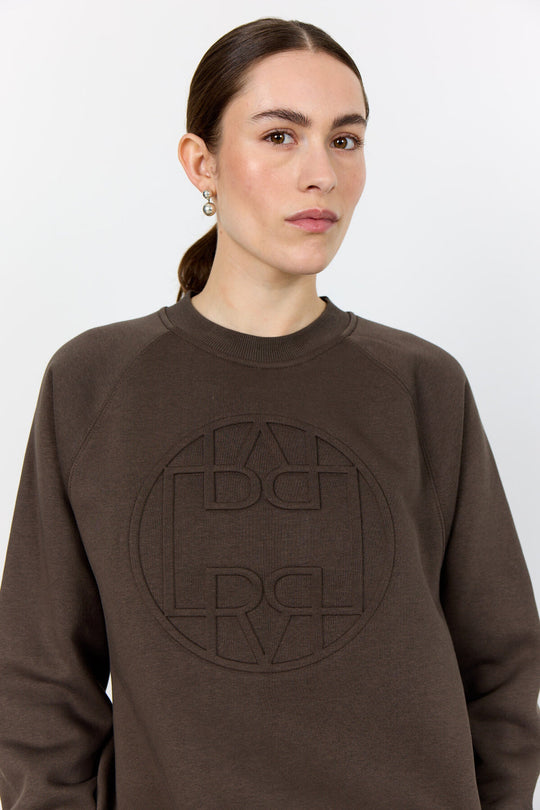 Levete Room LR-Nuka 11 sweatshirt, lavet af økologisk bomuld og genanvendt polyester, med cirkulært logo på forsiden.