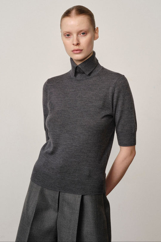 Perry Knit Blouse Grey – merinoudstrik med høj krave, taljelængde og gråt, rent look.
