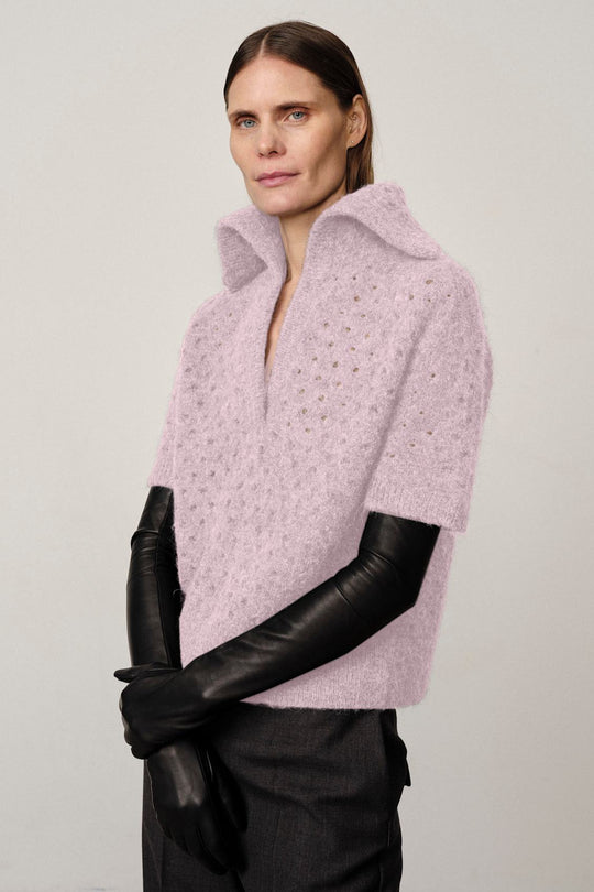 Herskind Bacon Knit Blouse Violet med kort ærme, V-udskæring, sejlerkrave og hulstrikmønster – alpaka- og uldblanding for varme og komfort.
