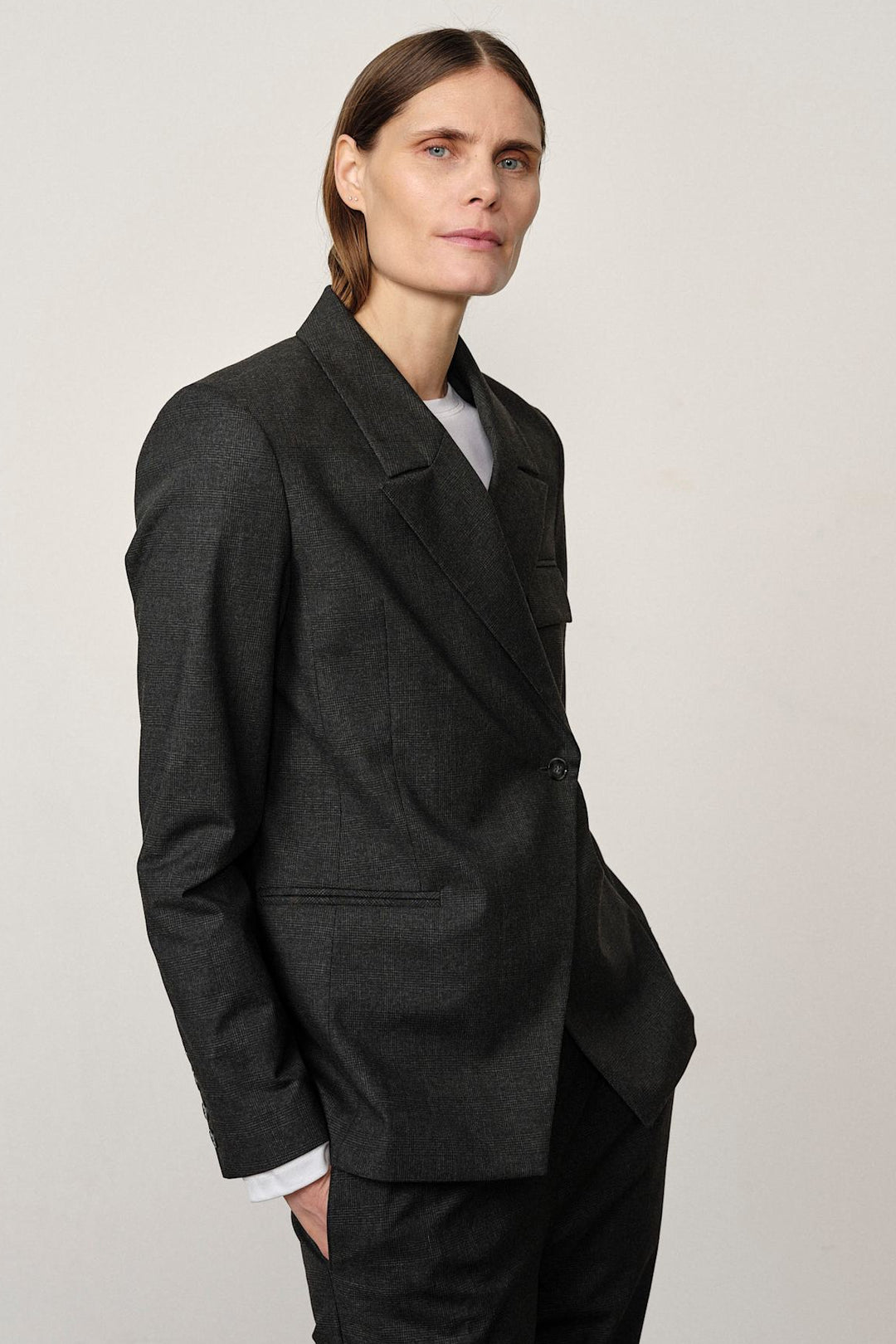 Herskind Oprah Regular Blazer i checks grey – struktureret blazer med paspolerede lommer og asymmetrisk frontlukning
