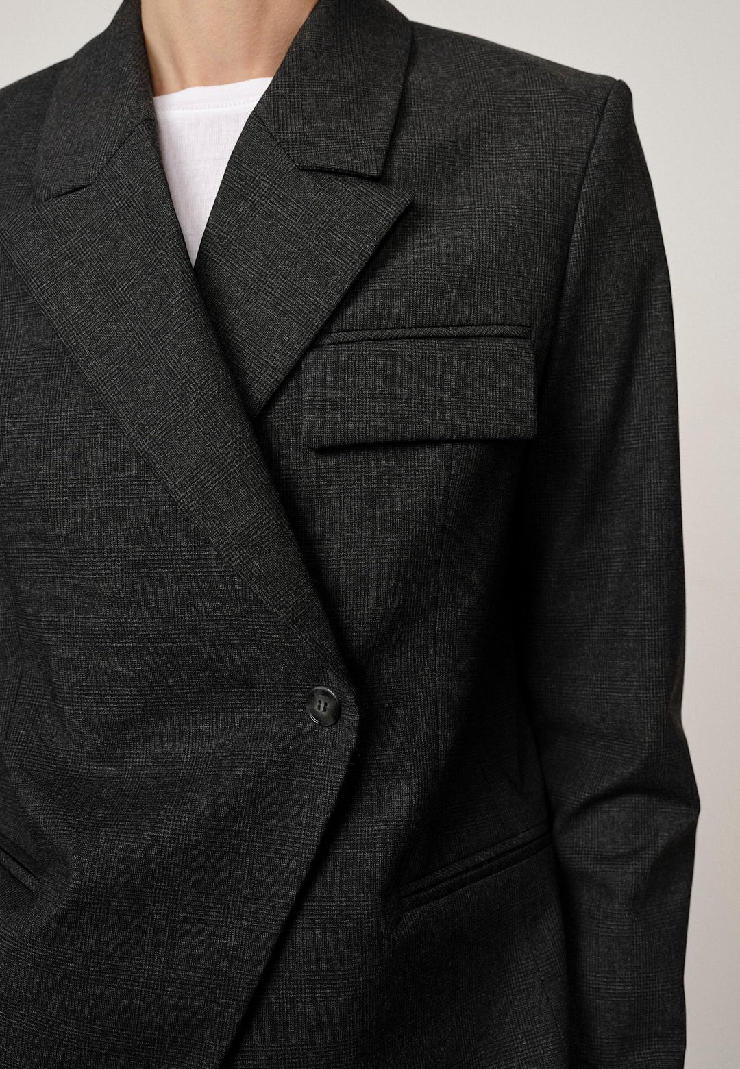 Herskind Oprah Regular Blazer i checks grey – struktureret blazer med paspolerede lommer og asymmetrisk frontlukning
