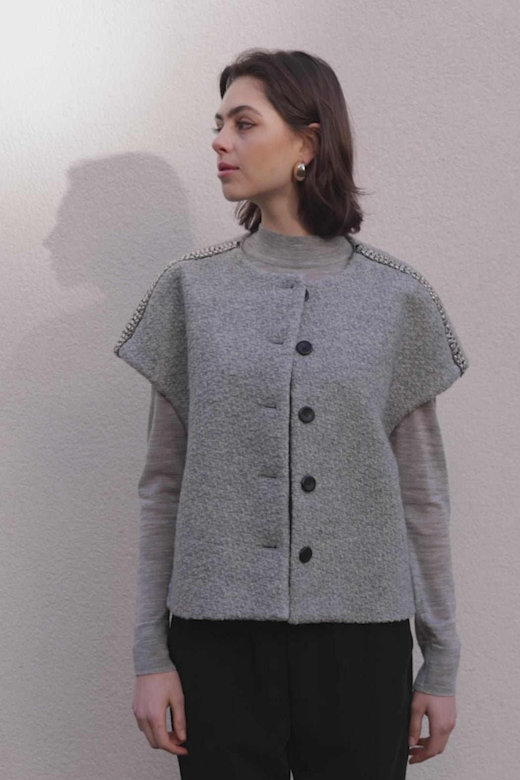 PBO Kino Cape i light grey – kort cape med rund hals og perle-detaljer over skuldrene.
