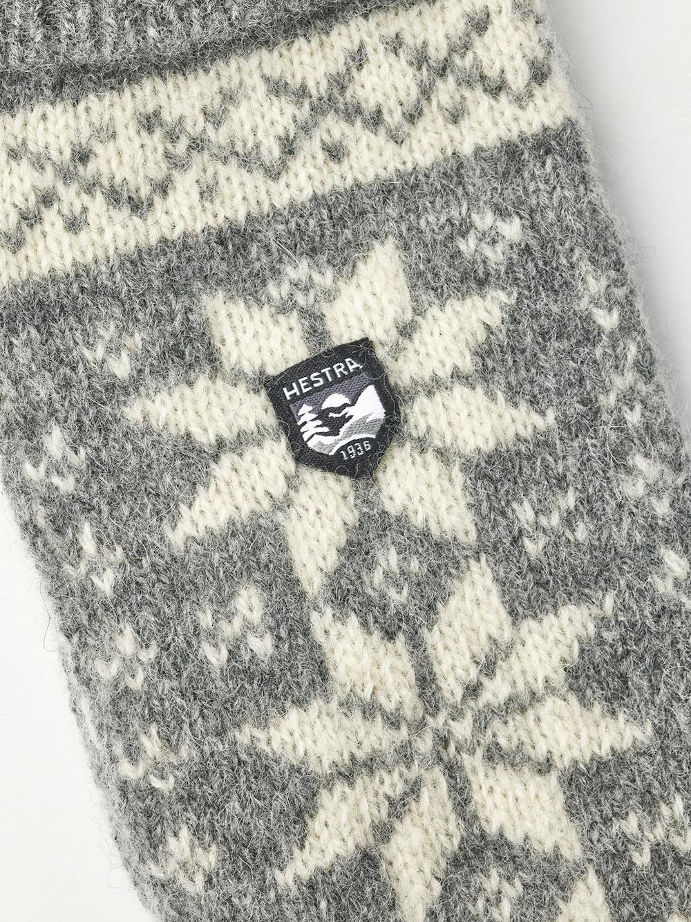 Hestra Isvik Mitt i farven Grey/Offwhite – strikket luffe i 80% uld, 20% polyamid med Fair Isle-mønster og ribstrikket manchet.
