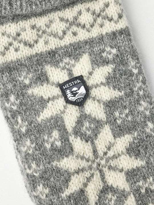Hestra Isvik Mitt i farven Grey/Offwhite – strikket luffe i 80% uld, 20% polyamid med Fair Isle-mønster og ribstrikket manchet.
