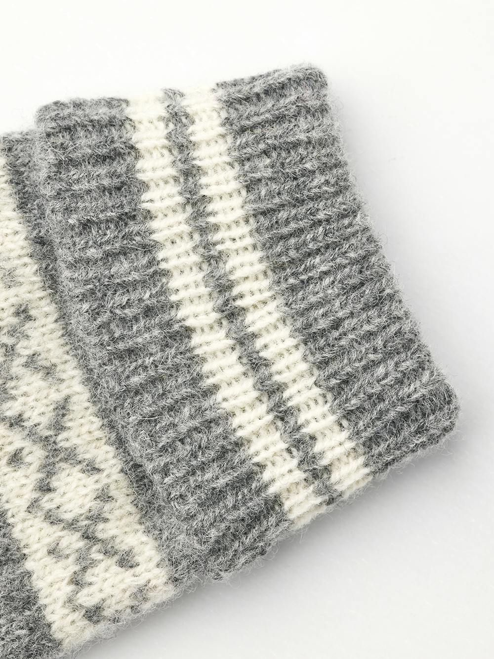 Hestra Isvik Mitt i farven Grey/Offwhite – strikket luffe i 80% uld, 20% polyamid med Fair Isle-mønster og ribstrikket manchet.
