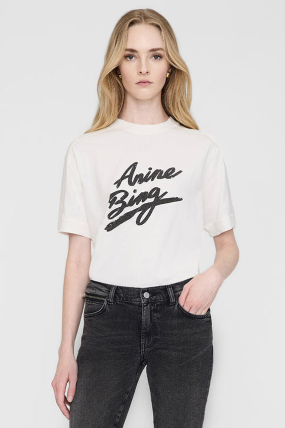 Anine Bing Jaylin Tee Signature i ivory. Boxy pasform med signatur ANINE BING grafik. Tidløs og komfortabel T-shirt i 100% bomuld.